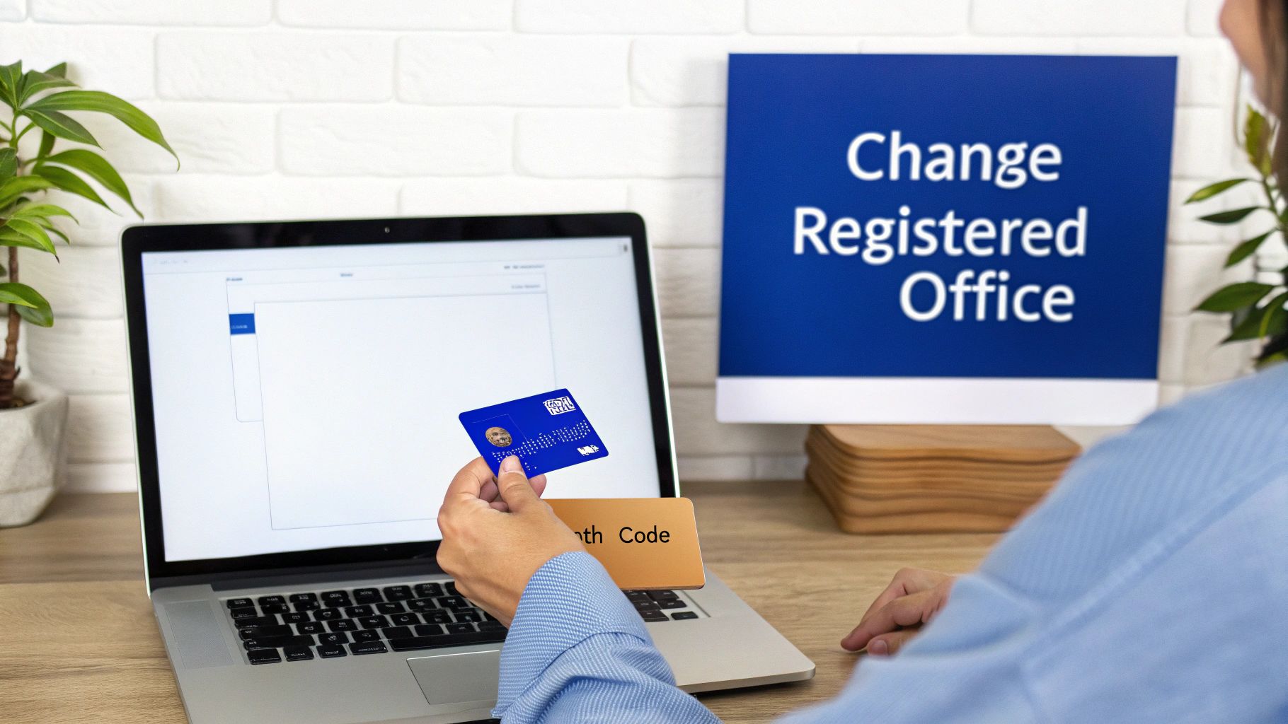 A person at a desk updating company details online, representing the process of changing a registered office address.