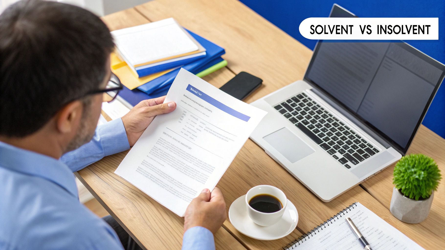 A group of business professionals in a meeting room, looking at documents on a table.